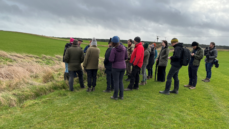 A crowd of people on a farm walk, learning about Whole Farm Planning at Lochhouses Farm