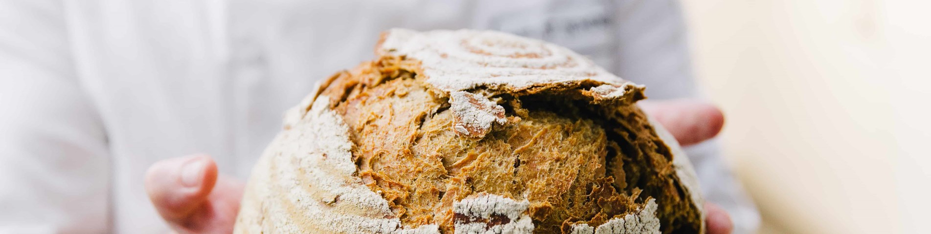 Organic bread in chef hands Cafe St Honore Organic Served Here award holder.jpg