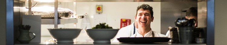 Photo of Paul Collins, Chef at Yeo Valley Canteen, laughing in the kitchen