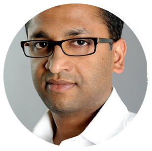 Headshot of Cocofina founder, Jacob Thundil, a man wearing a white shirt and glasses