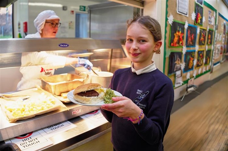 A school pupil receiving their school meal