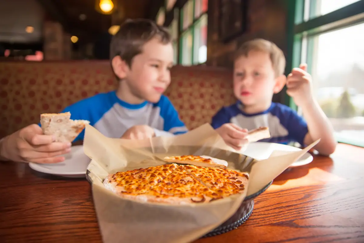Two children eating pizza