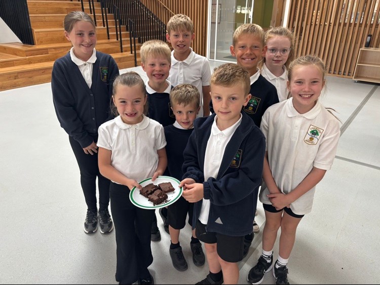 Primary school pupils holding a plate of brownies