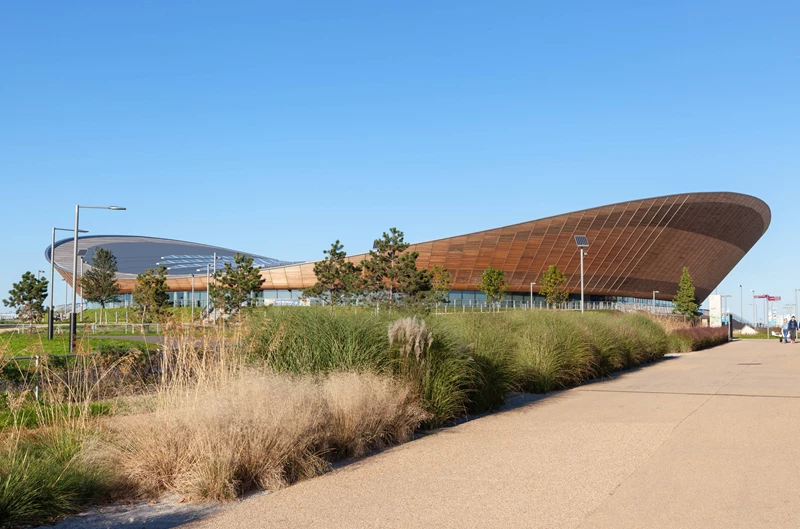 Exterior of the Velodrome, a large building with natural curves and lots of timber