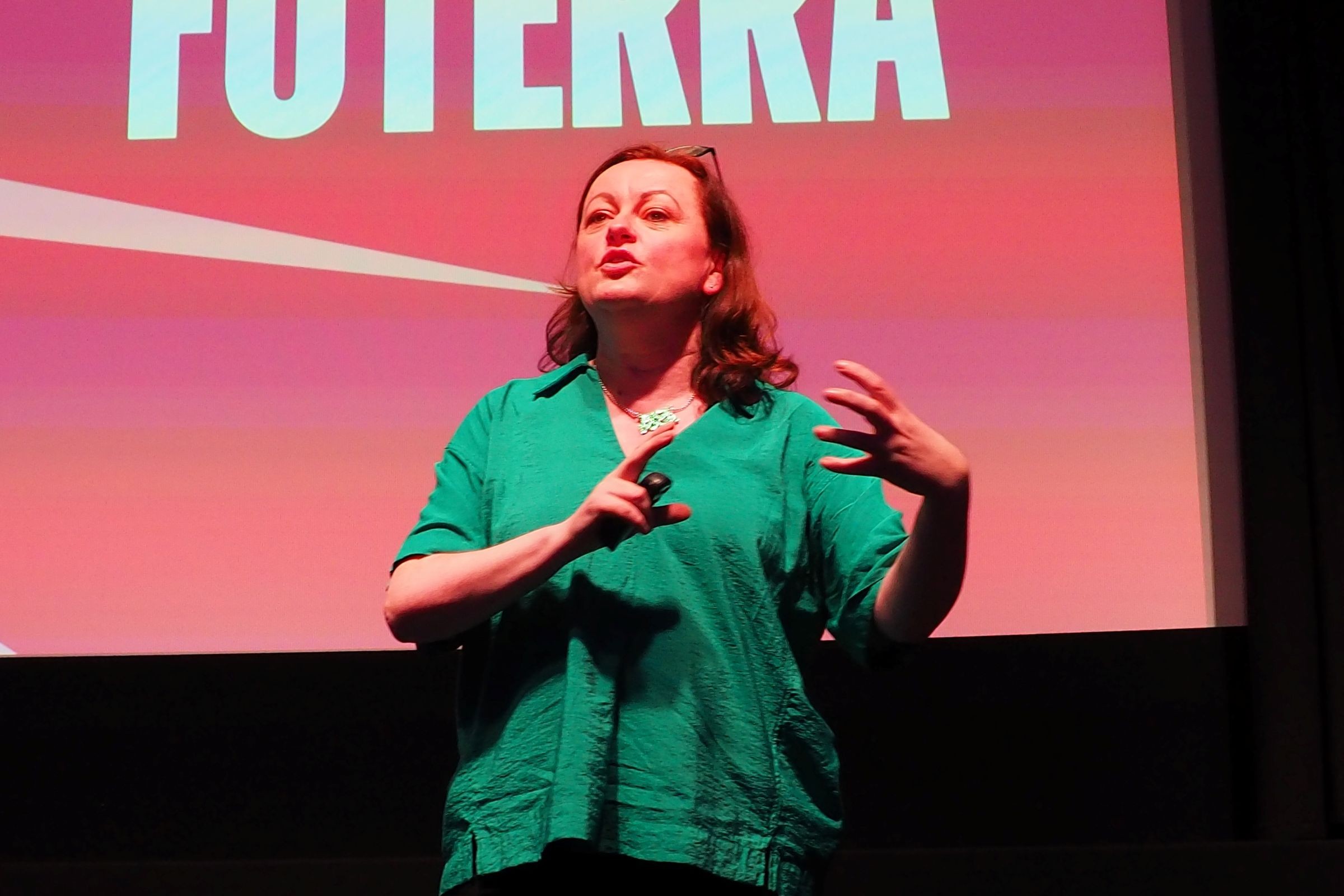 A woman giving a keynote address on stage