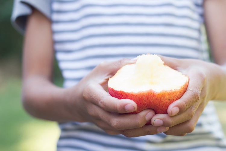 child holding half eaten apple