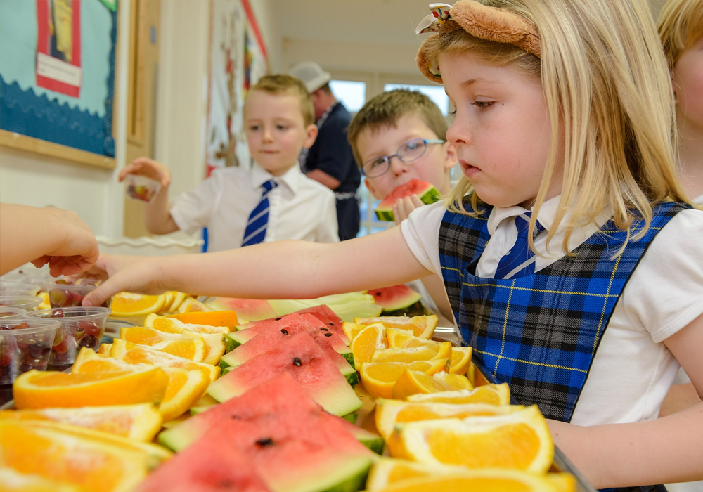 Children choosing a selection of fruit in school