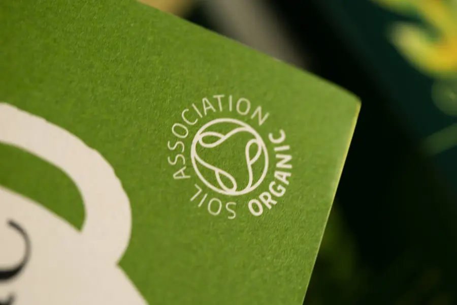 The Soil Association organic logo on a bright cardboard pack of Clipper tea