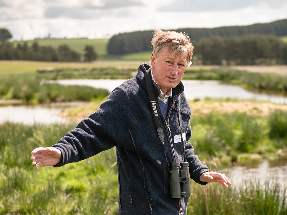 Colin Strang Steel of Threepwood Farm pictured mid-conversation, in front of numerous ponds or wetlands.