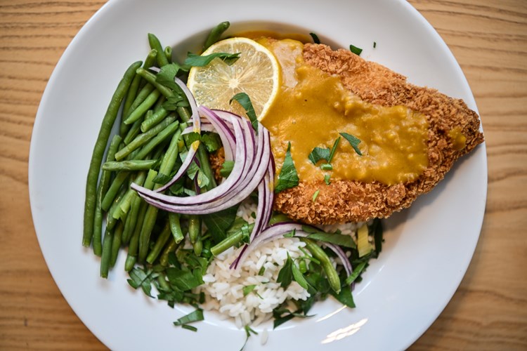 A plate of food with green beans, breaded fillet and rice