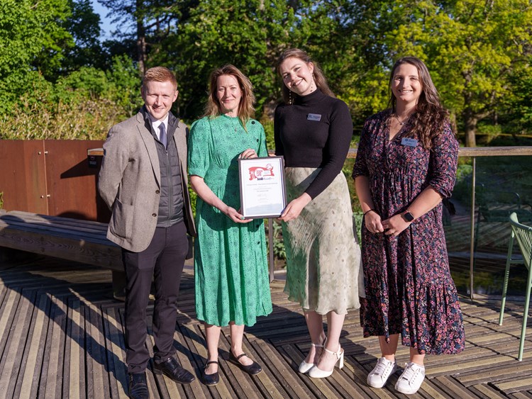 four people receiving an award