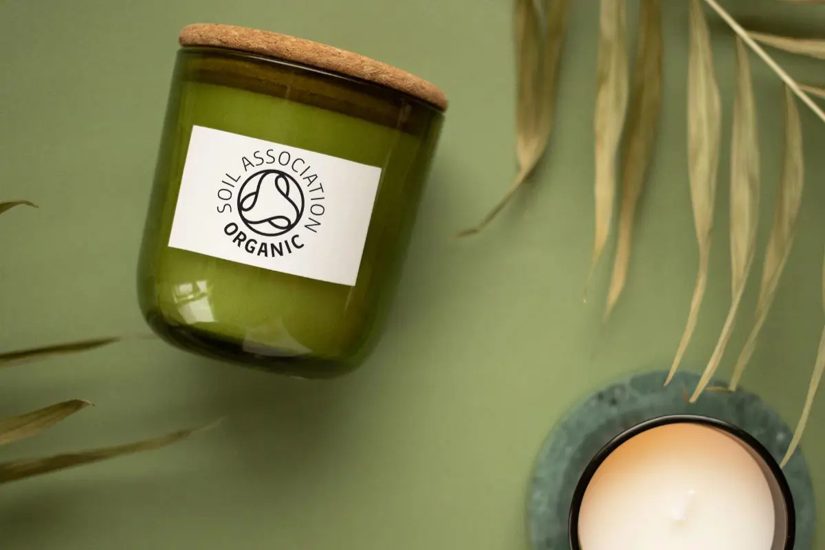 Two candles with glass jars and cork lids, bearing the Soil Association organic symbol