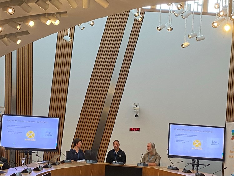 A panel of people in a conference hall