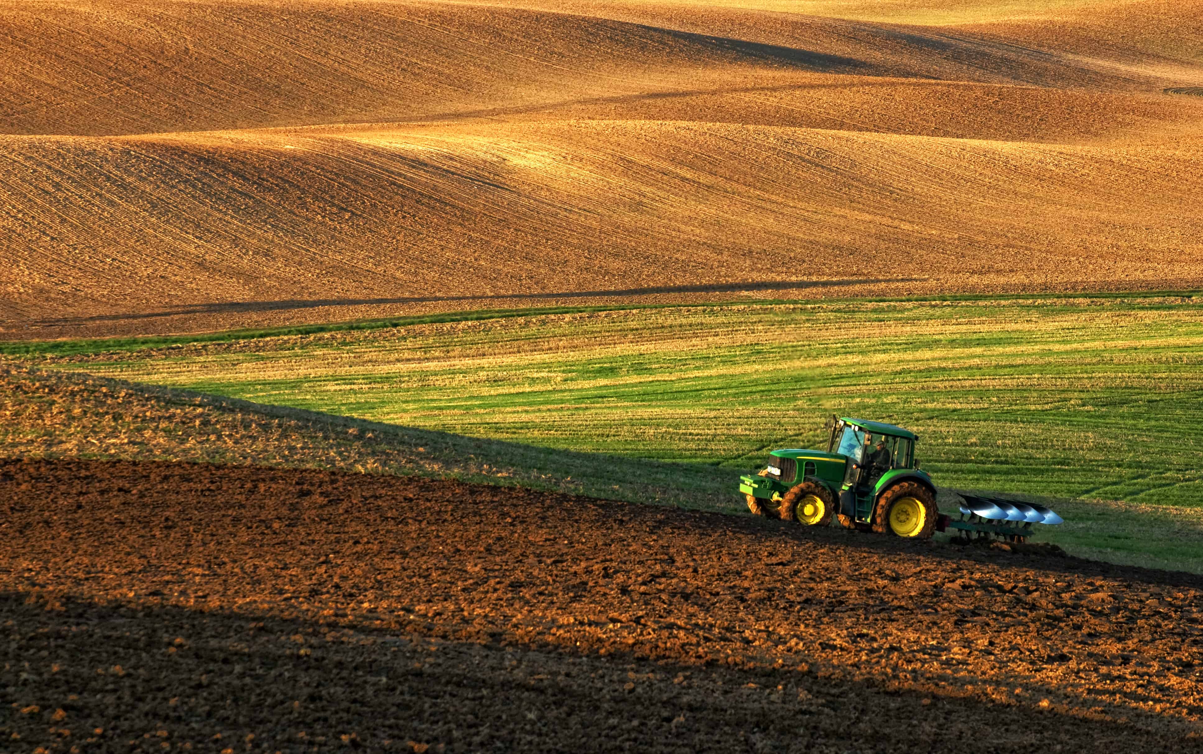 Tractor pulling plough.