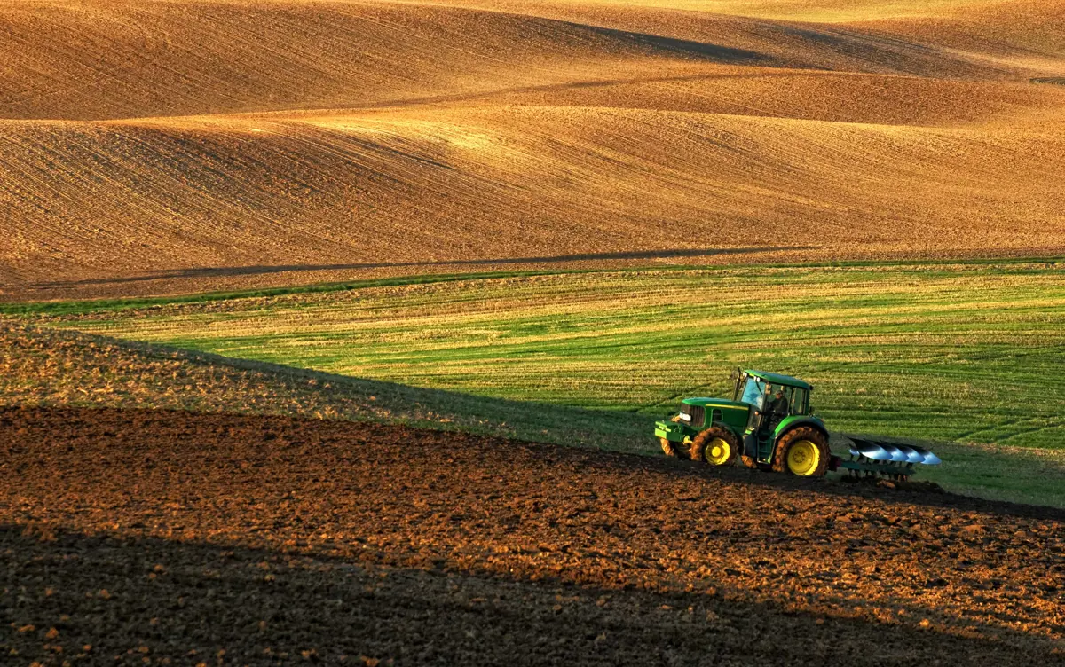 Tractor pulling plough.