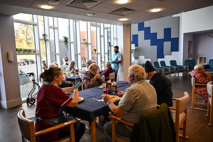 A group of people eating around tables