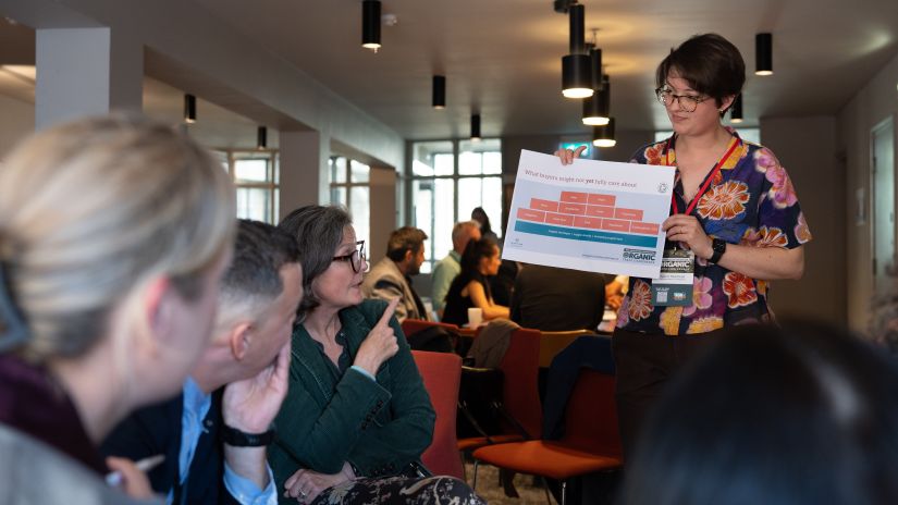 A woman holding up presentation slides for a breakout session