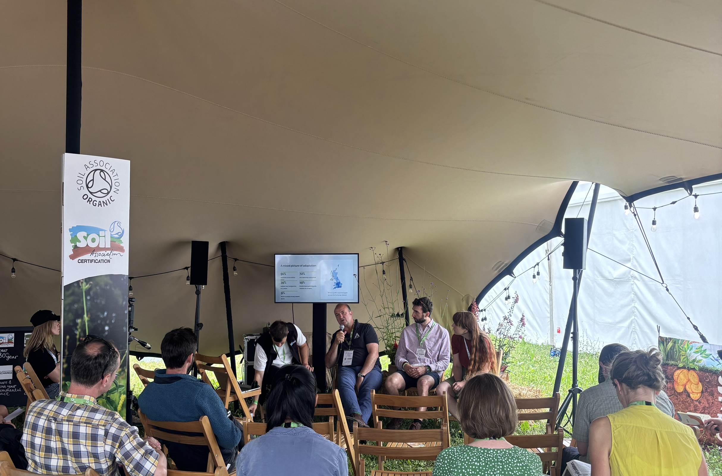 A presentation from Groundswell, with speakers delivering a talk held in a tent