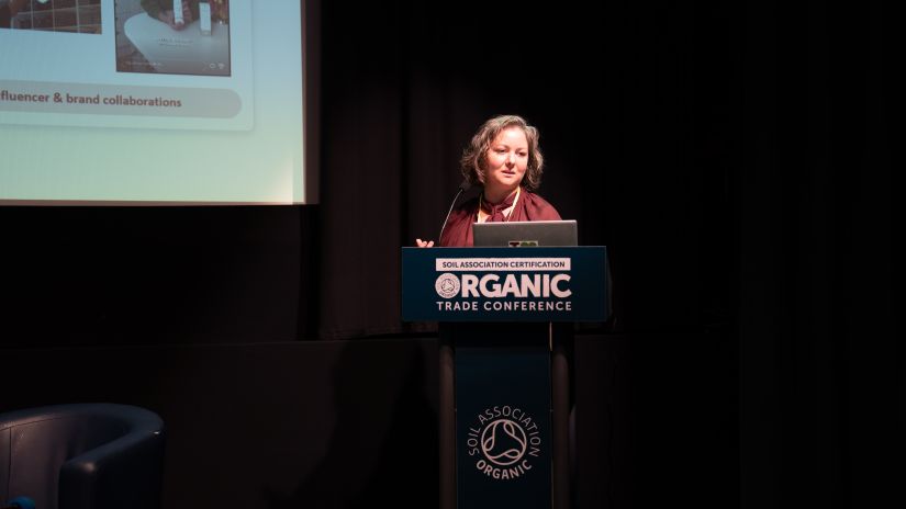 A woman on stage presenting at a lectern