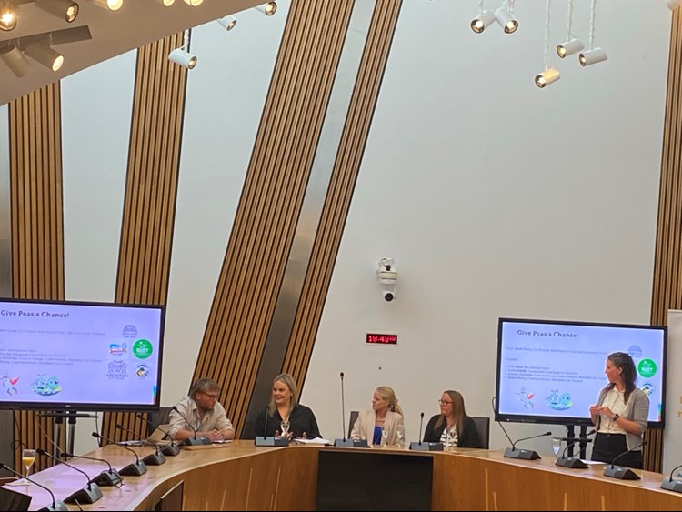 A panel of people in a conference hall