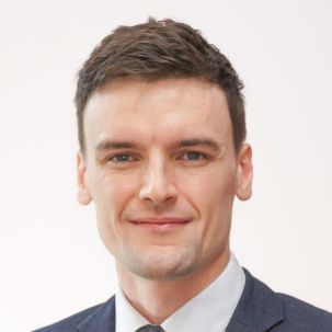 A clean shaven man in a suit and tie