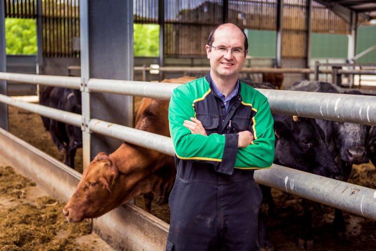 Sion Williams poses in front of cattleshed