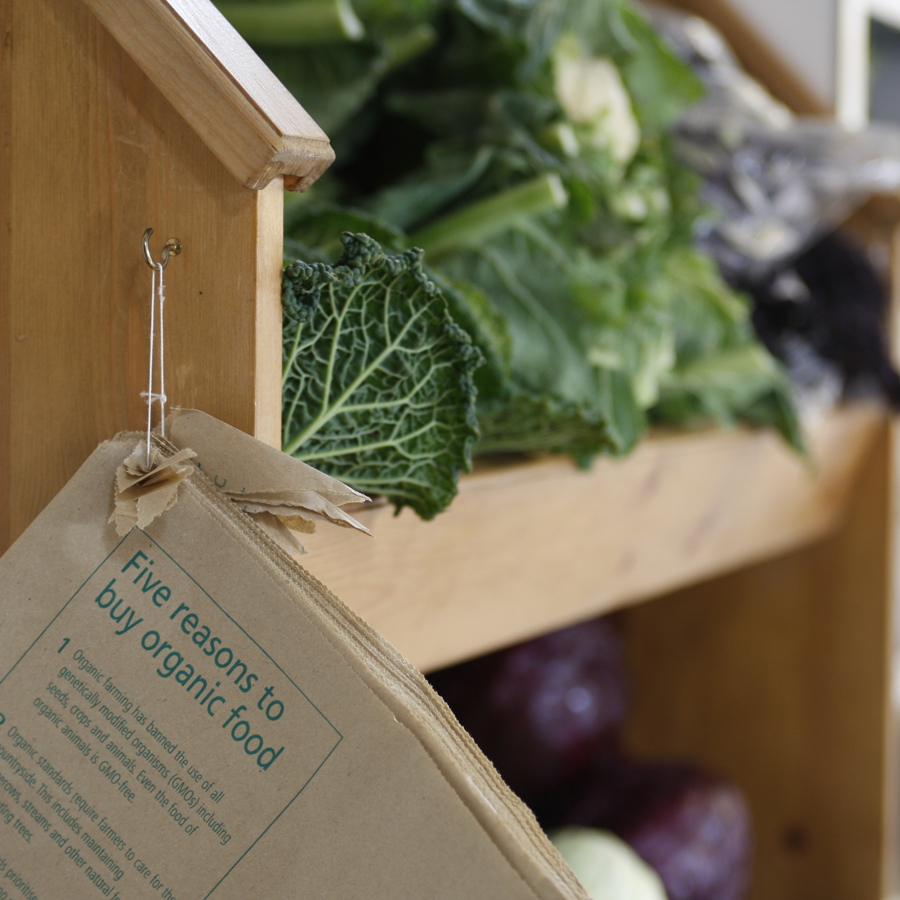Fresh vegetables on a shelf with brown paper bags