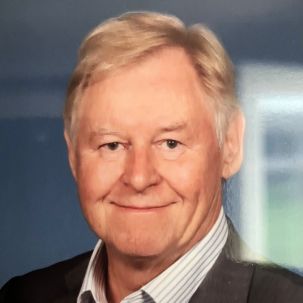 Smiling man in a sit with sandy hair