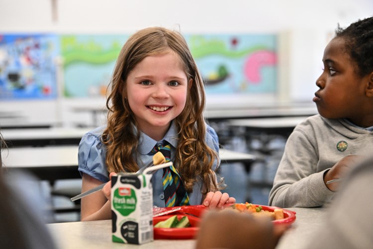 A primary school pupil eating their school meal