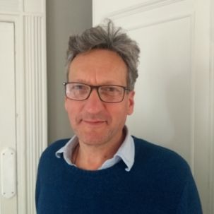 Smiling man with glasses and grey hair